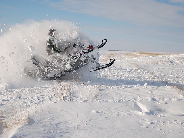 This photograph was taken by my wife Jill Medby. I was blasting through a drift on the edge of a creek. The camera was a Nikon D80, with full auto settings and a 18mm to 135mm lens.  I am wearing my 1972 Artic Cat snowmobile suit.