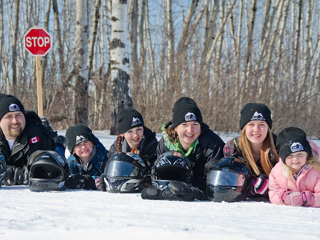 Snowmobile family, posed on the trail