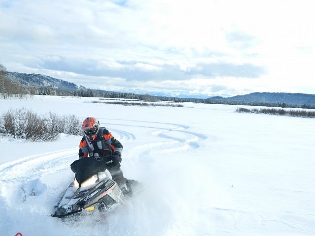 carving in the snow-teton mountains in background