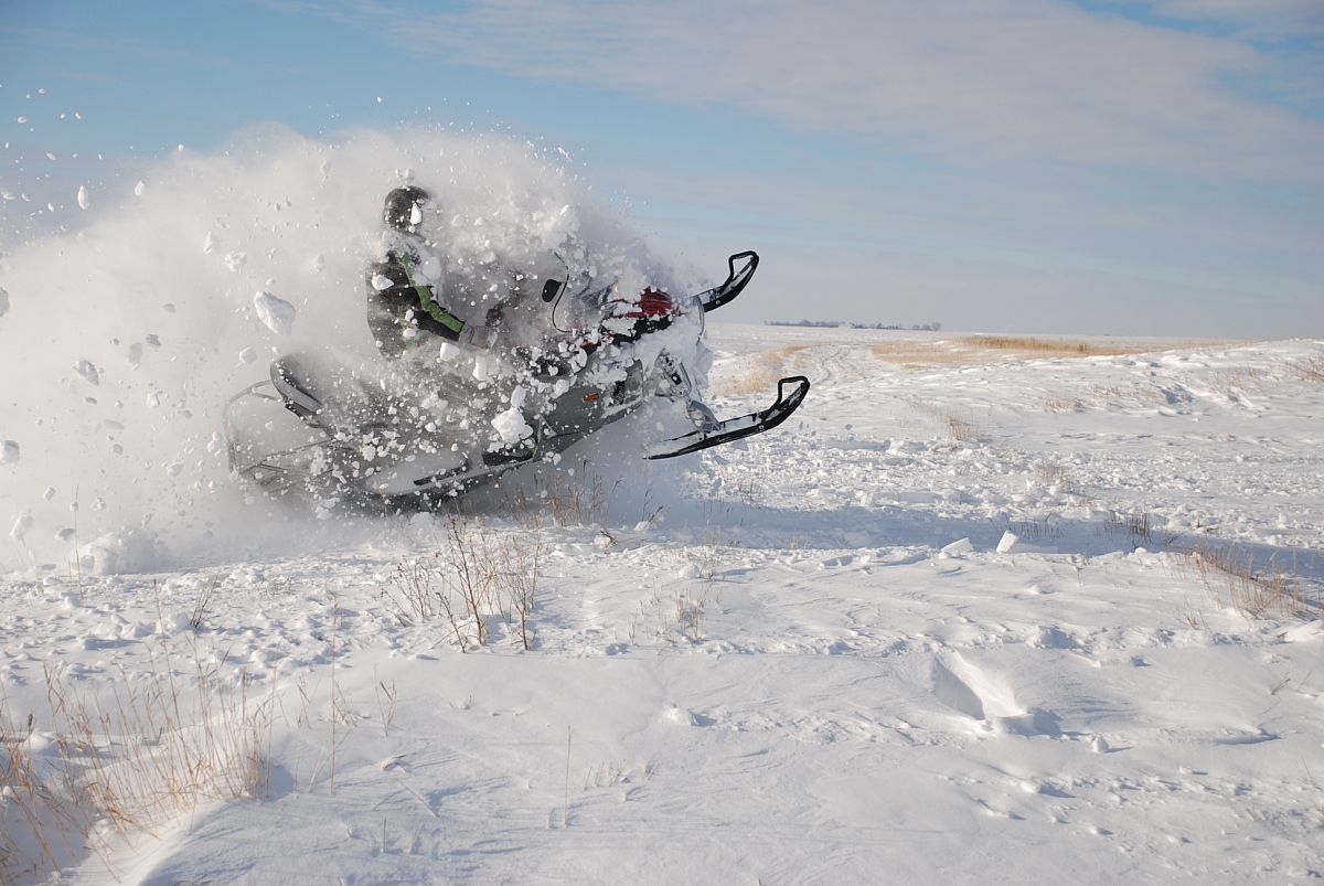 This photograph was taken by my wife Jill Medby. I was blasting through a drift on the edge of a creek. The camera was a Nikon D80, with full auto settings and a 18mm to 135mm lens.  I am wearing my 1972 Artic Cat snowmobile suit.