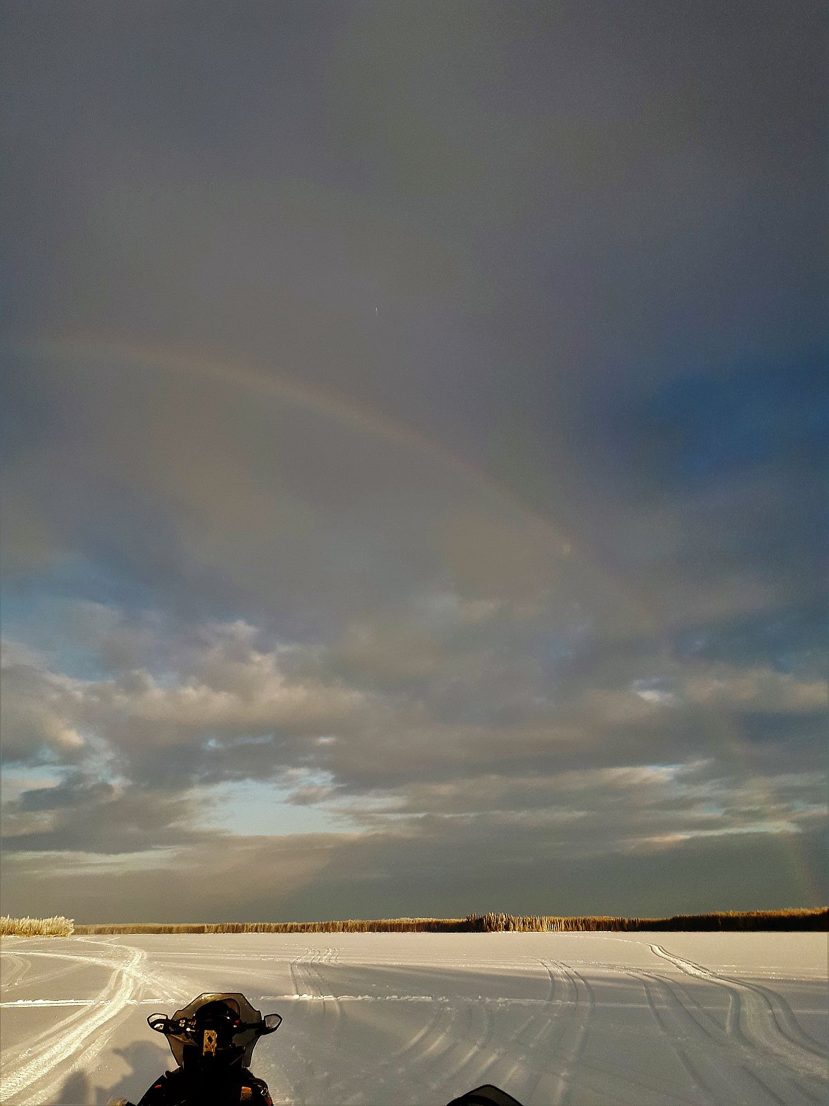 Snowmobiling in January with a rainbow overhead!